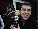 Former Vancouver Giants player Milan Lucic holds his bobble-head doll after a Bruins practice in Vancouver in 2011.
