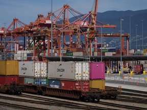 A transport truck carries a cargo container to the Centerm Container Terminal at port in Vancouver on Friday, July 14, 2023. The Canada Industrial Relations Board has released the new terms of the agreement that resolved British Columbia's port dispute, including a commitment by employers to train workers to perform maintenance on new equipment.