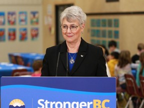 BC Finance Minister Katrine Conroy answers questions from reporters after serving up a hot lunch for students at Ruth King Elementary during a photo-op ahead of the budget while in Langford, B.C., on Feb. 27, 2023. An audited public accounting of British Columbia's financial records shows the province posted a budget surplus of $704 million in the 2022-2023 budget year.