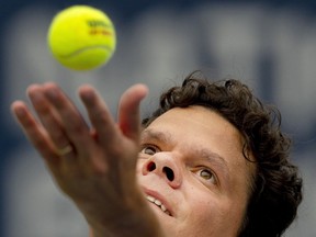 Milos Raonic of Canada tosses the ball to serve to Mackenzie McDonald of the United States in tennis action at the National Bank Open in Toronto, Thursday, Aug. 10, 2023.