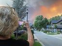 Wendy Creelman taking photos of the West Kelowna wildfire Thursday night from in front of her house in Kelowna's Glenmore Highlands, not long before she and her daughter Alexa, visiting from Vancouver, were forced to flee after the fire jumped Okanagan Lake.