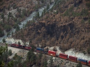 The Transportation Safety Board of Canada is warning about the risks of fires going unnoticed on locomotives, citing dozens of blazes in a report into an incident that triggered a wildfire two years ago in southeast British Columbia. A Canadian Pacific freight train travels on tracks covered with fire retardant in an area burned by wildfire above the Thompson River near Lytton, B.C., on Sunday, August 15, 2021.
