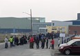 People without vehicles line up to register for a flight to Calgary in Yellowknife on Thursday, Aug. 17, 2023
