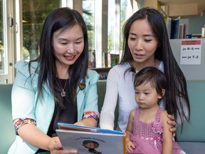 The province is donating $500,000 to literacy programs, including the Vancouver Sun's Raise-a-Reader campaign. Pictured: Minister of Municipal Affairs Anne Kang reads to Vivianna Yao and her mother, Cindy Liu, at the Burnaby Public Library Summer Read Club Wrap-up event. 0923 rar kang Photo credit: Herman Thind / Government of BC [PNG Merlin Archive]