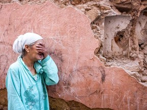 A woman reacts standing in front of her earthquake-damaged house in the old city in Marrakesh on Sept. 9.