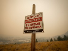 A 43-year-old Kamloops, B.C., woman has been sentenced for two arson fires she admitted to setting. A warning sign about fire risk is seen as smoke from wildfires fills the air, in Kelowna, B.C., Saturday, Aug. 19, 2023.