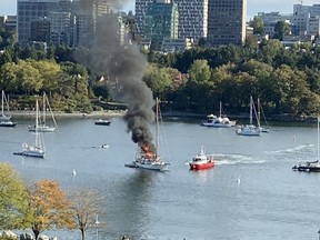 A pleasure craft burns in Vancouver's False Creek Thursday, Sept. 7, 2023. Vancouver Fire and Rescue says a man may have been cooking when the fire broke out in the waters off David Lam Park in Yaletown.