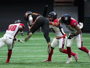 B.C. Lions' Jevon Cottoy, second left, is upended as he's tackled by Ottawa Redblacks' Deandre Lamont, from left to right, Damon Webb and Justin Howell during the first half of a CFL football game in Vancouver Sept. 16, 2023.