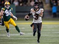 B.C. Lions quarterback Vernon Adams Jr. (3) runs the ball as Edmonton Elks' Jake Ceresna (94) looks on during first half CFL action in Edmonton on September 22, 2023.