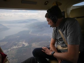 B.C. Premier David Eby looks out at Scotch Creek, B.C., while viewing areas of the Shuswap affected by the Bush Creek East wildfire on a helicopter flight from Kamloops to Salmon Arm, on Monday, Sept. 11, 2023.