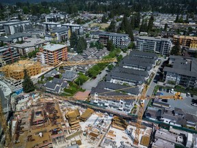 Cranes are seen above a condo development and other housing projects under construction in Coquitlam, B.C., on Tuesday, May 16, 2023. British Columbia's government is aiming to speed up the construction of new homes and secondary suites by releasing new guides and programs to help streamline the process.