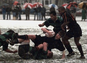 VANCOUVER, BC - Jan 20, 1996 -- Vancouver Meralomas player Rob mullen hangs onto the ball while his teamate Courtney Smith #14 watches him get pulled to the ground by a Cowichan player during interlock rugby action play at Connaught Park. Province staff photo by Les Bazso. [PNG Merlin Archive]