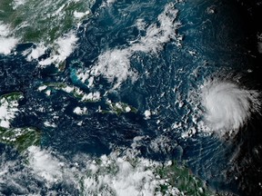 This satellite image provided by the National Oceanographic and Atmospheric Administration shows Hurricane Lee, right, in the Atlantic Ocean on Friday, Sept. 8, 2023, at 4:50 p.m. EDT. Lee is rewriting old rules of meteorology, leaving experts astonished at how rapidly it grew into a goliath Category 5 hurricane. (NOAA via AP)