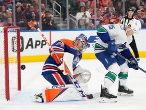 Edmonton Oilers goalie Stuart Skinner (74) makes a save on Vancouver Canucks Sheldon Dries (15) during second period NHL preseason action on Wednesday, Sept. 27, 2023 in Edmonton.