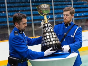 New Westminster police officers Christopher O'Brien (left) and Dan Horton carry the Mann Cup into a luncheon hosted by the New Westminster Salmonbellies lacrosse team at Queen's Park Arena in New Westminster on Thursday. The Salmonbellies' bid for the Cup begins Friday against the Six Nations Chiefs.