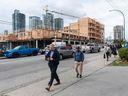 People walk past a multi-unit rental building under construction at 6889 Royal Oak Avenue in Burnaby on Sept. 27, 2023. 