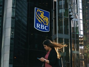 The latest RBC survey shows financial uncertainty has become the new normal for many Canadians as inflation remains high. A woman walks past a Royal Bank of Canada sign in the financial district in Toronto on Tuesday, Sept. 20, 2022.
