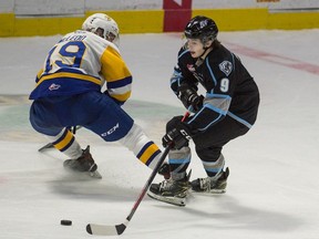 The Winnipeg Ice's Zach Benson tries to keep the puck from the Saskatoon Blades' Wyatt McLeod during a WHL game at the Brandt Centre in Regina on March 17, 2021.