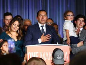 Manitoba premier-designate Wab Kinew, centre, gives his victory speech at NDP provincial election night headquarters in Winnipeg on Tuesday.