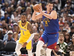 Denver Nuggets' Nikola Jokic collects the ball as Los Angeles Lakers guard D'Angelo Russell watches.