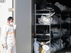 Forensic staff look on as a refrigerated container holding the bodies of Israeli citizens killed during the recent attacks by Hamas is opened, in Ramla, Israel, on Friday.