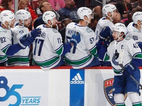 Quinn Hughes of the Vancouver Canucks is congratulated by teammates after he scored a first period goal against the Florida Panthers at the Amerant Bank Arena on October 21, 2023 in Sunrise, Florida.