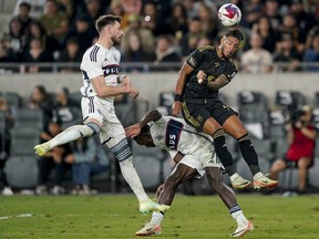 Los Angeles FC forward Denis Bouanga, top right, jumps over Vancouver Whitecaps midfielder Richie Laryea in front of Tristan Blackmon during the second half Saturday's playoff game in Los Angeles.