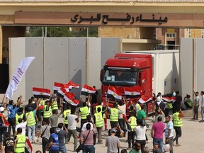 Egyptian aid workers celebrate as a truck crosses back into Egypt through the Rafah border crossing with the Gaza Strip on October 21, 2023.
