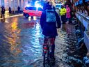 A cyclist passes a flooded street in Flensburg, norhtern Germany on October 20, 2023 as Storm Babet caused havoc. (Photo by Axel Heimken / AFP)
