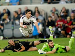 Vancouver Whitecaps forward Brian White, top watches his goal past Los Angeles FC defender Giorgio Chiellini, bottom left, and goalkeeper Maxime Crepeau during the first half of an MLS playoff match Saturday, Oct. 28, 2023, in Los Angeles.
