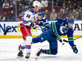 New York Rangers' Will Cuylle and Vancouver Canucks' Carson Soucy get tangled up during the first period of NHL game in Vancouver Oct. 28, 2023.