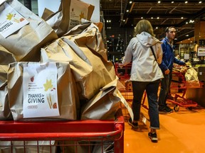 A cart is filled with pre-filled bags of food, during a Thanksgiving food drive for the Ottawa Food Bank at a grocery store in Ottawa, on Saturday, Oct. 7, 2023.