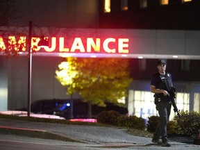 A law enforcement officer carries a rifle outside Central Maine Medical Center during an active shooter situation, in Lewiston, Maine, Wednesday, Oct. 25, 2023.