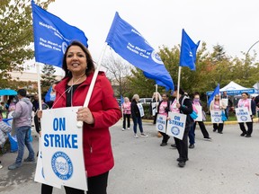 Meena Brisard (red coat) protests outside Delta View Care Centre on October 20, 2023.