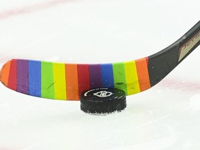A hockey stick is shown with rainbow-coloured hockey tape before an NHL game in Ottawa on Wednesday, April 28, 2021.&ampnbsp;Longtime NHL executive Brian Burke says the NHL's decision to ban on-ice support for community causes, which includes the use of rainbow-coloured stick tape on Pride nights, is a "surprising and serious setback."