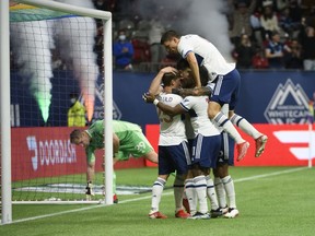 The Vancouver Whitecaps celebrate midfielder Ryan Gauld’s goal against Sporting Kansas City keeper Tim Melia during their Oct. 17, 2021, MLS game at B.C. Place.