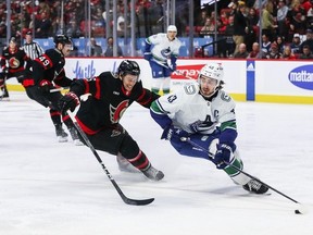 Quinn Hughes of the Canucks skates with the puck against Matthew Highmore of the Senators during the second period at Canadian Tire Centre on Nov. 9, 2023 in Ottawa.