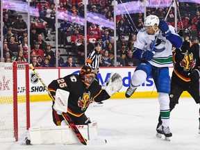 Jacob Markstrom of the Calgary Flames stops a shot from Dakota Joshua of the Vancouver Canucks during the first period of an NHL game at Scotiabank Saddledome on Nov. 16, 2023 in Calgary.