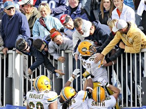 Football fans celebrate with Edmonton Eskimos running Calvin McCarty after he scored a touchdown against the Toronto Argonauts during the first-ever CFL regular season game in Atlantic Canada, at Stade Moncton in 2010.
