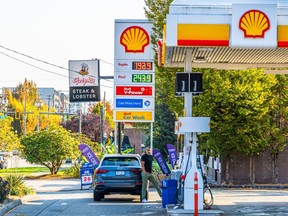 A man fills his tank in Port Moody, B.C., in 2022, as gas price approach $2 per litre.