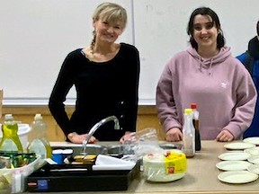 Vice principal Chayne den Ouden (left) and youth care worker Kiya Machon get breakfast ready for students at Abbotsford Middle School.