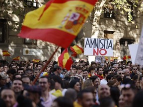 A demonstrator holds a sign reading 'Amnesty no' during a protest called by right-wing opposition against an amnesty bill for people involved with Catalonia's failed 2017 independence bid, in front of the PSOE (Spain's Socialist Party) headquarters in Madrid on November 12, 2023. Right-wingers and far-right demonstrators have gathered in Madrid in tense protests for a week, against the government's proposed law granting amnesty to Catalan separatists. (Photo by OSCAR DEL POZO / AFP)