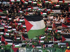 Celtic fans in the stands wave Palestinian flags ahead of the Champions League Group E match between Celtic Glasgow and Atletico Madrid on Oct. 25.