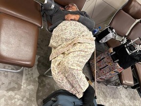 An Air Canada passenger tries to get some rest at Baku International Airport in Azerbaijan after a flight from Toronto to India was forced to land due to a mechanical issue.