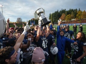 UBC Thunderbirds' Mitchell Townsend (centre) hoists the Mitchell Bowl as he and his teammates celebrate after defeating the St. Francis Xavier X-Men during the U Sports Mitchell Bowl university football game, in Vancouver on Saturday, Nov. 18, 2023.