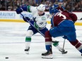 Vancouver Canucks left wing Nils Hoglander, left, and Colorado Avalanche defenceman Jack Johnson pursue the puck during the second period
