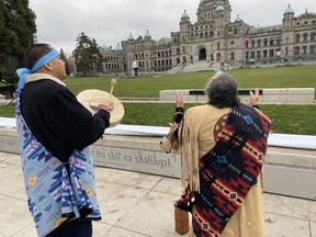 Elder Mary Ann Thomas and Charlie George, of the B.C. Association of Aboriginal Centres, welcome the new Indigenous signage unveiled on the grounds of the B.C. legislature, once the site of an Indigenous village, in Victoria on Wednesday Nov. 29, 2023.