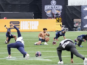 Montreal Alouettes defensive lineman Mustafa Johnson, centre, wears no shirt and warms up during practice ahead of the 110th CFL Grey Cup against the Winnipeg Blue Bombers in Hamilton, Ont., Friday, Nov. 17, 2023.