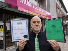 Dana Larsen of the Medicinal Mushroom Dispensary shows off his Vancouver Coastal Health permit to operate and his City of Vancouver business licence outside his shop on East Hastings Street.