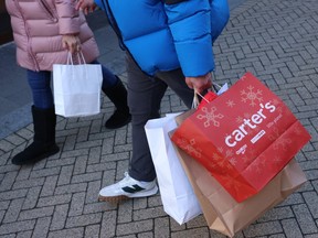 A shopper holds bags on Black Friday at McArthurGlen outlet mall in Richmond.
